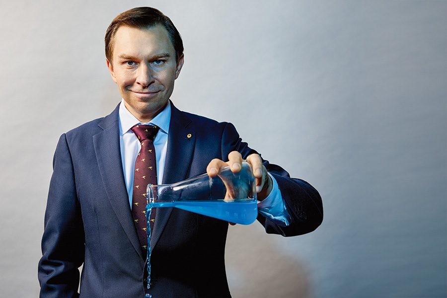 David Sinclair pouring a blue liquid from a glass jug